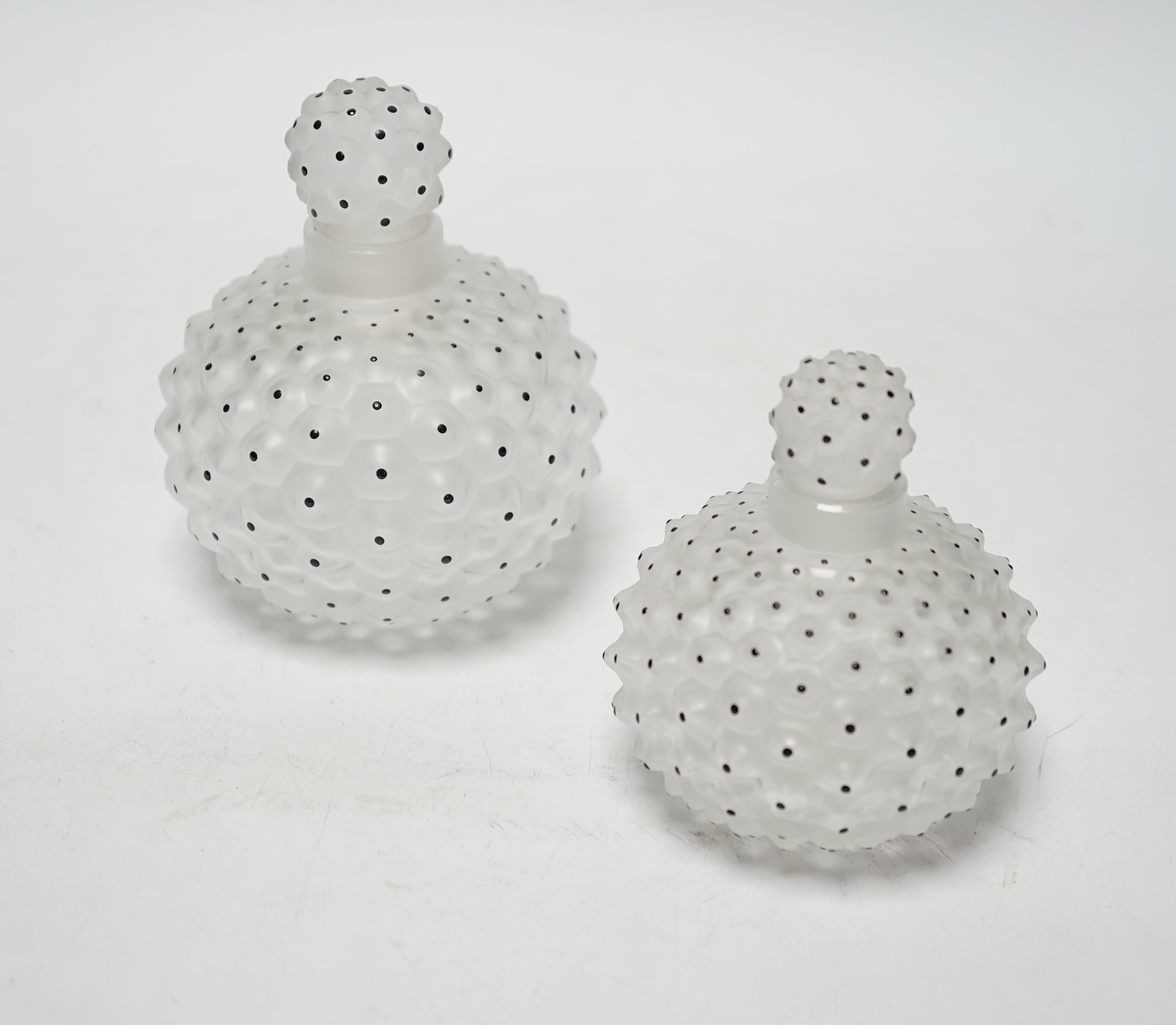 Two Lalique graduated cactus pattern glass scent bottles and stoppers, one with label to the base, largest 12cm high